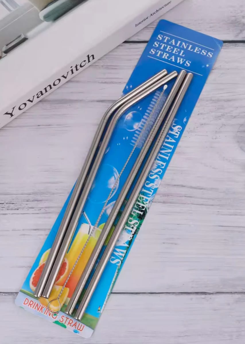 Two stainless steel straws in a blue and green package on a wooden surface.