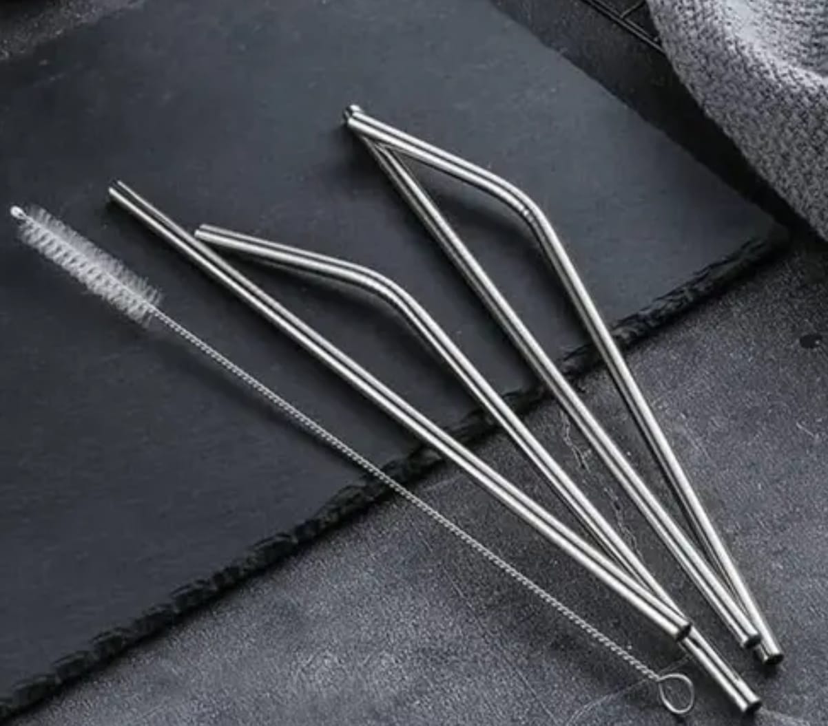 Set of metal straws on a dark surface
